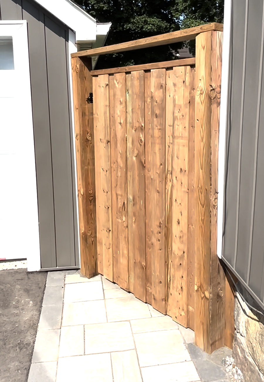 Custom wood gate installation between two buildings in Oshawa