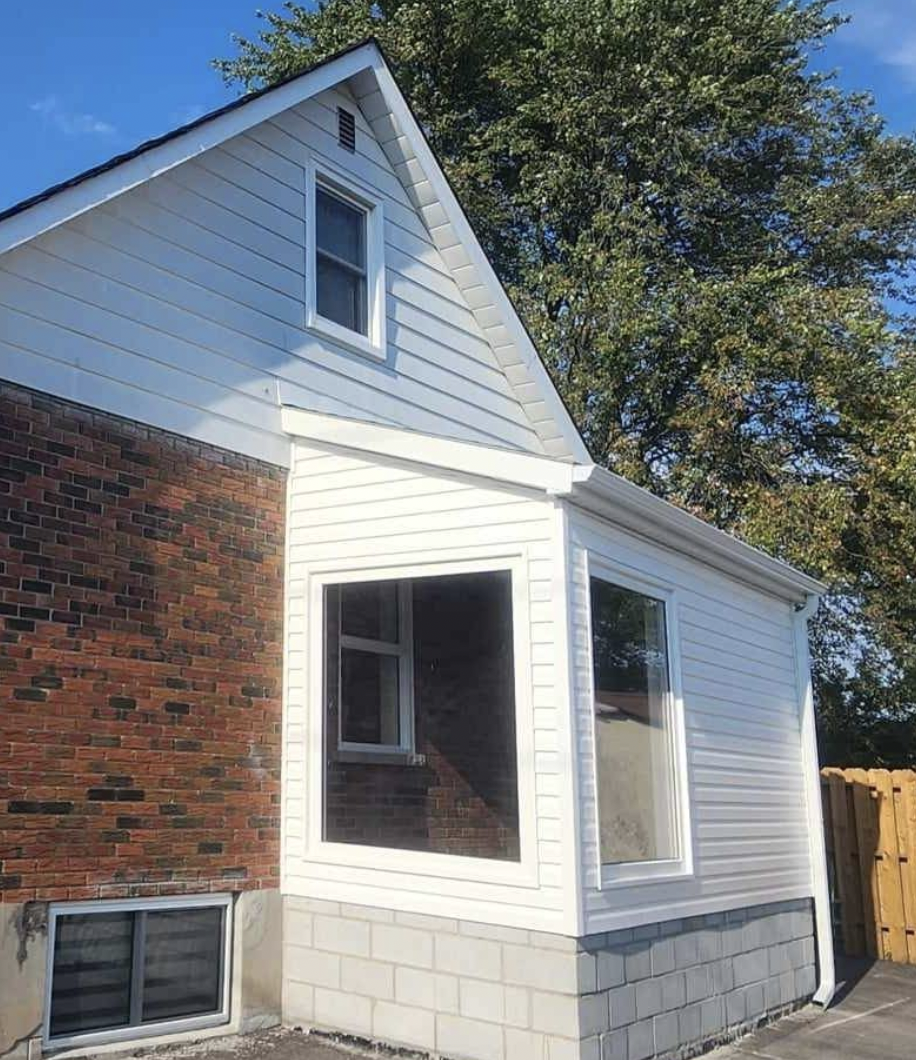 Oshawa Vinyl Siding Replacement – Wilworks Renovations White vinyl siding and aluminum flashing installation on Oshawa home with brick and cinderblock exterior.